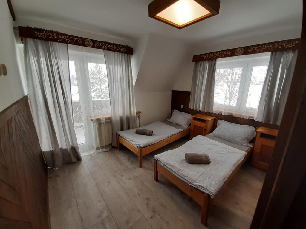 a room with two beds and two windows at Na wierchu in Ząb