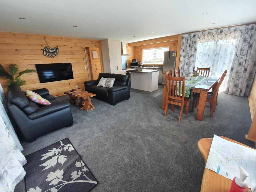 ein Wohnzimmer mit einem Sofa und einem Esszimmer in der Unterkunft Folia Domus NZ, Redwoods, MBT in Rotorua