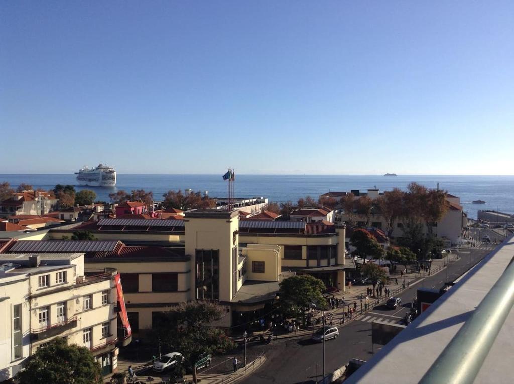 een stadsstraat met gebouwen en de oceaan op de achtergrond bij Top Floor City Center - Mercado, privileged view in Funchal