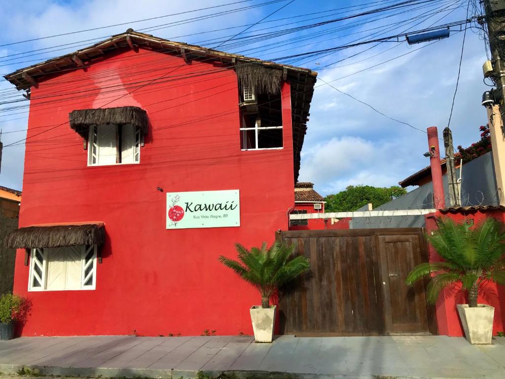a red building with a white sign on it at Pousada Kawaii in Arraial d'Ajuda