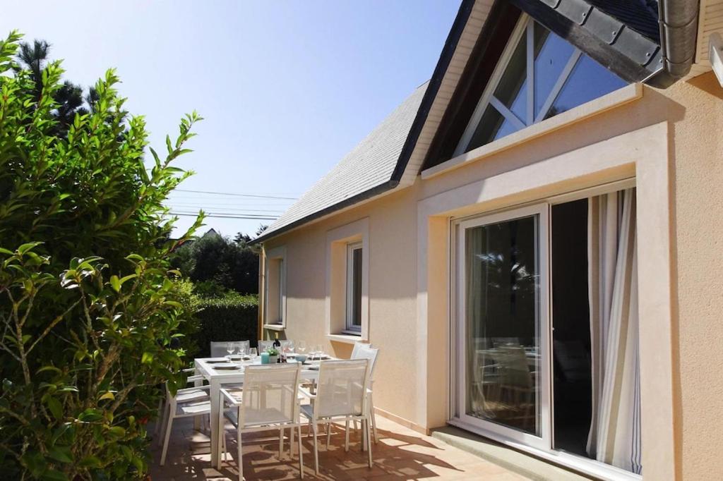 eine Terrasse mit einem Tisch und Stühlen auf dem Balkon in der Unterkunft Cottage, Saint Germain sur Ay in Saint-Germain-sur-Ay