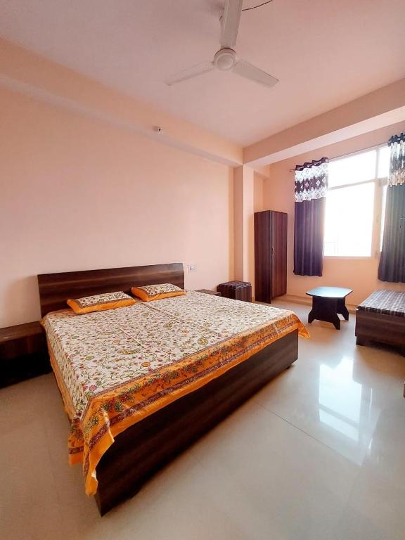 ein Schlafzimmer mit einem großen Bett und einem Fenster in der Unterkunft Gautam Sadan II in KumhÄrsain