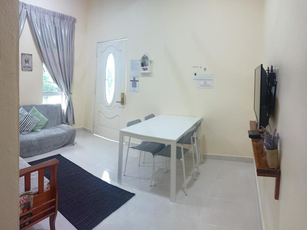 a living room with a white table and a couch at Topville Homestay in Kangar