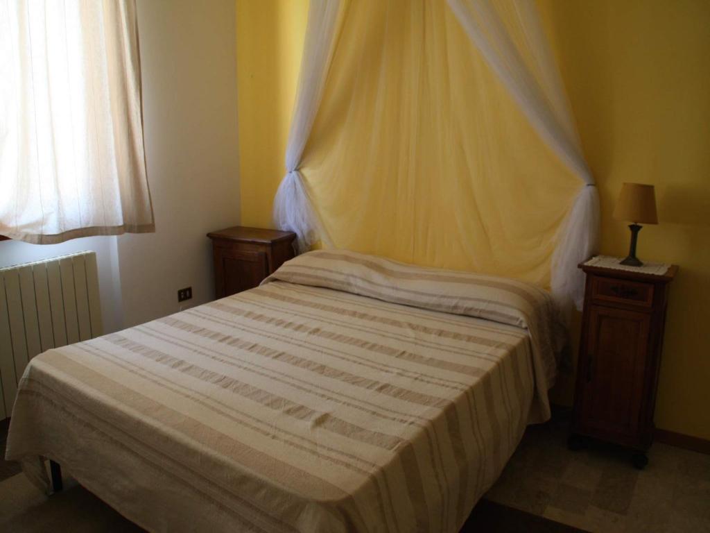 a bedroom with a bed with a white comforter at Cristina B&B in Sassoferrato