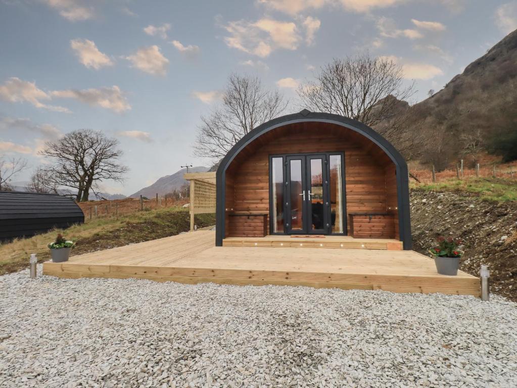 a small cabin with a wooden deck on a hill at The Stag - Crossgate Luxury Glamping in Penrith