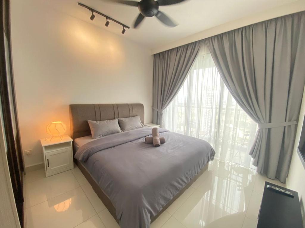 um quarto com uma cama e uma ventoinha de tecto em Teega Suites, Puteri Harbour, Iskandar Puteri em Nusajaya