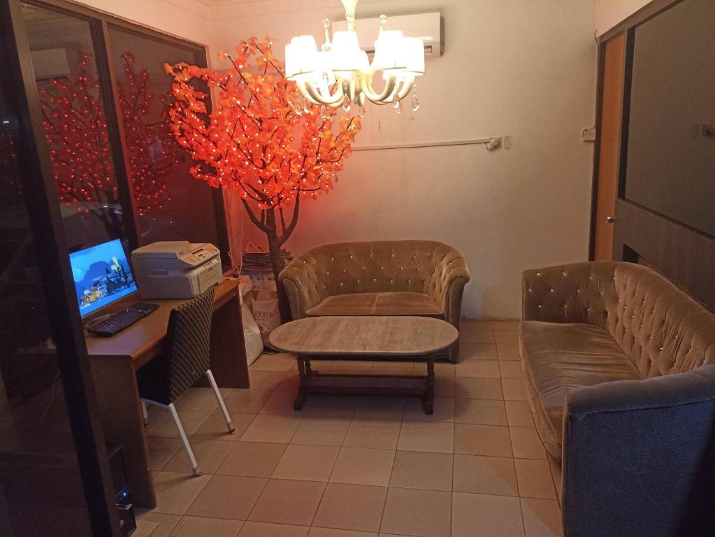 OYO 90809 Oriental Hotel في Sarikei: غرفة انتظار مع كرسي ومكتب مع جهاز كمبيوتر