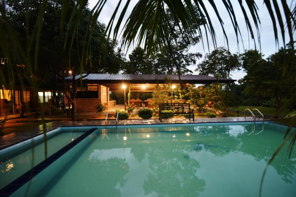 a swimming pool in front of a house at Ele Camp Udawalawe in Udawalawe