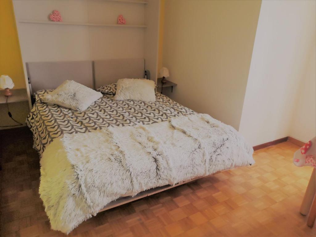 a bedroom with a bed with a white comforter and pillows at Il nido di Asia CIR N0310 in Breuil-Cervinia