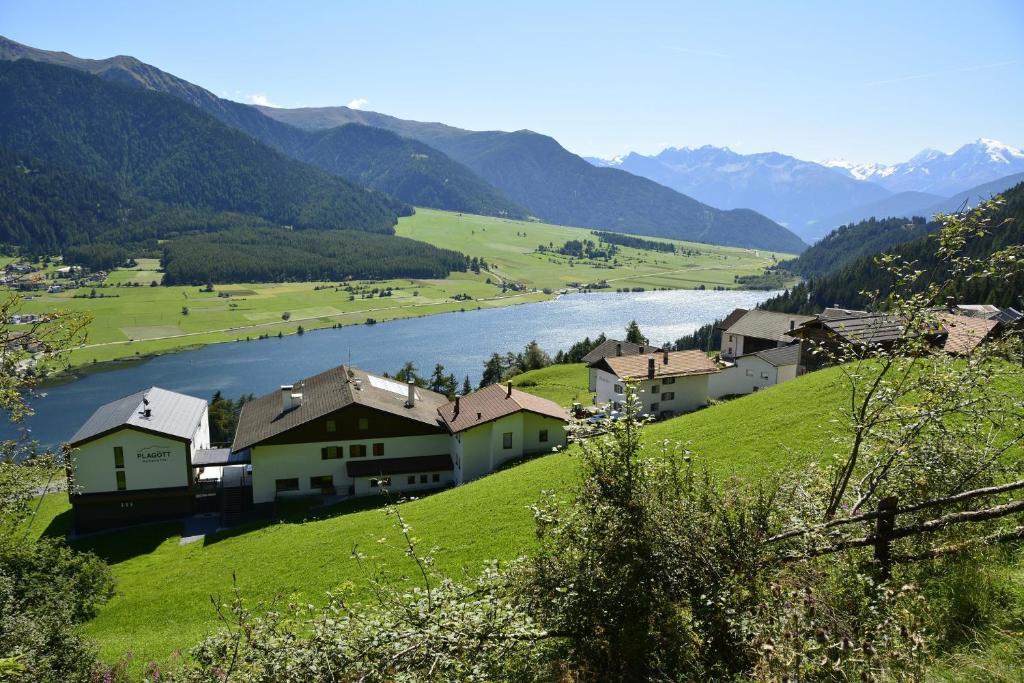 un pueblo en una colina con un río y montañas en Berghotel Plagött en San Valentino alla Muta