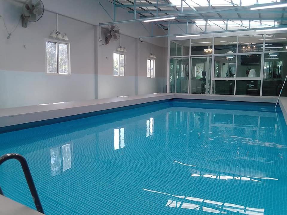ein großes Schwimmbecken mit blauem Wasser in einem Gebäude in der Unterkunft Cessna Park Resort and Hotel in Ban Hua Na