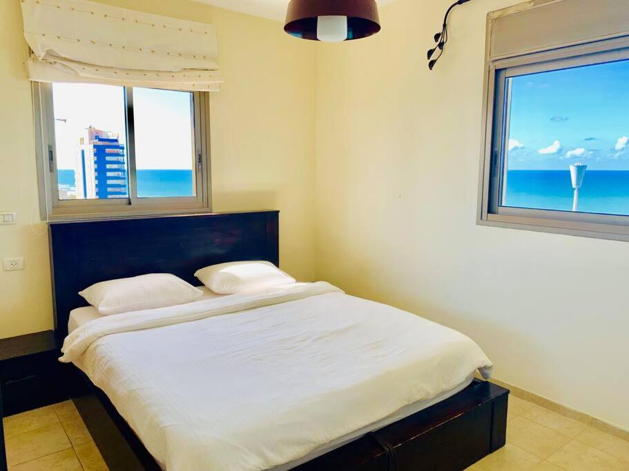 - une chambre avec un lit et une vue sur l'océan dans l'établissement Royal King David Apartment, à Netanya