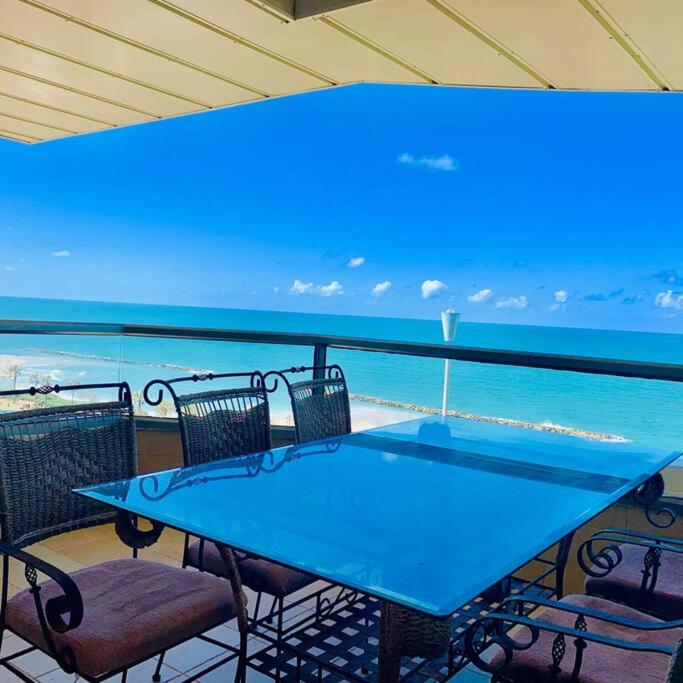 a blue table and chairs on a balcony with the ocean at Royal King David Apartment in Netanya