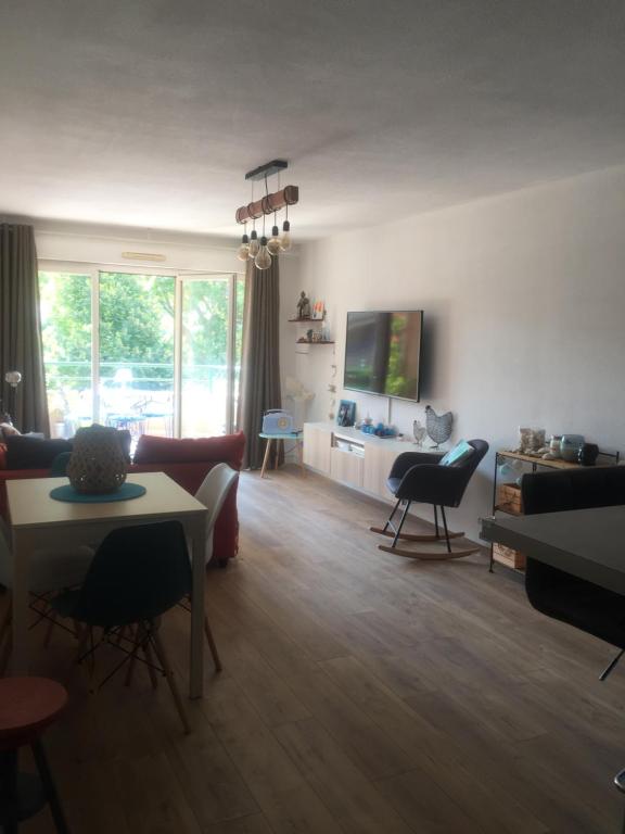 a living room with a couch and a tv at T3 Saint Cyr sur Mer 83270 in Saint-Cyr-sur-Mer