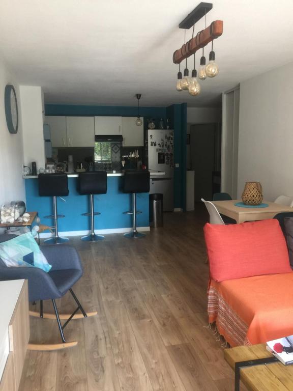 a living room with a couch and a kitchen at T3 Saint Cyr sur Mer 83270 in Saint-Cyr-sur-Mer