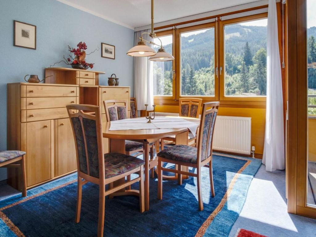 ein Esszimmer mit einem Tisch, Stühlen und einem Fenster in der Unterkunft Appartement Dorfblick in Bad Kleinkirchheim