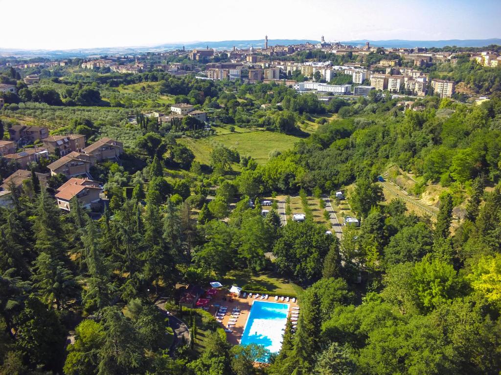 Una vista aérea de un complejo turístico con piscina y árboles. en Camping Siena Colleverde, en Siena
