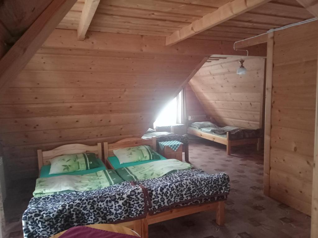 a room with two beds in a log cabin at Pokoje gościnne w górach in Kościelisko