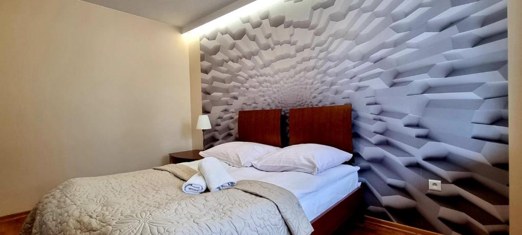 a bedroom with a bed with a large wall at Apartament Widokowy Maki in Zakopane