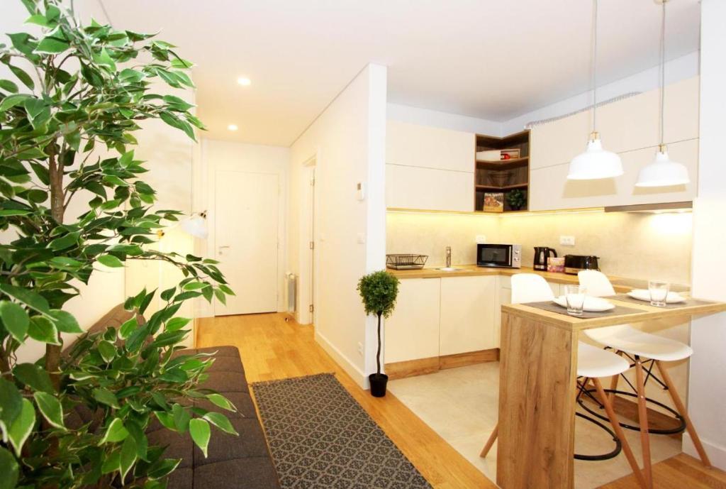 a kitchen with white cabinets and a table with chairs at Apartment SUN CITY 1 in Belgrade