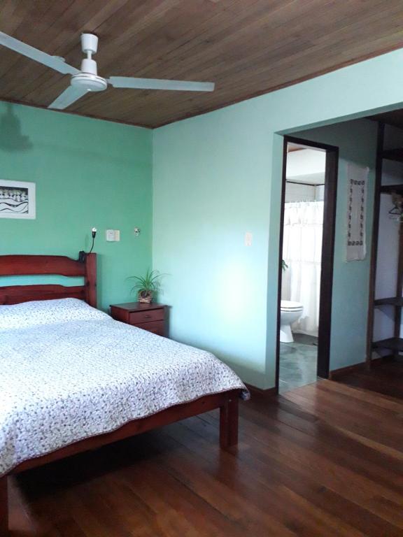 um quarto com uma cama e uma ventoinha de tecto em Jardín de Naipí em Porto Iguaçu
