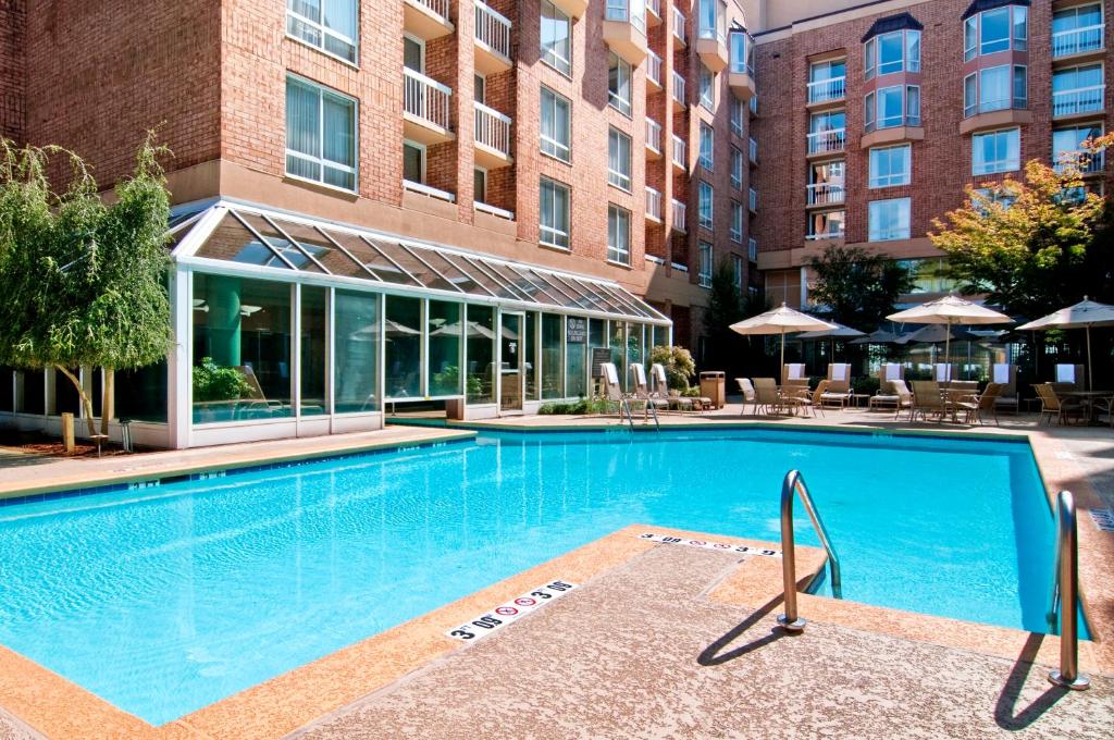 a large swimming pool in front of a building at Hilton Atlanta Perimeter Suites in Atlanta