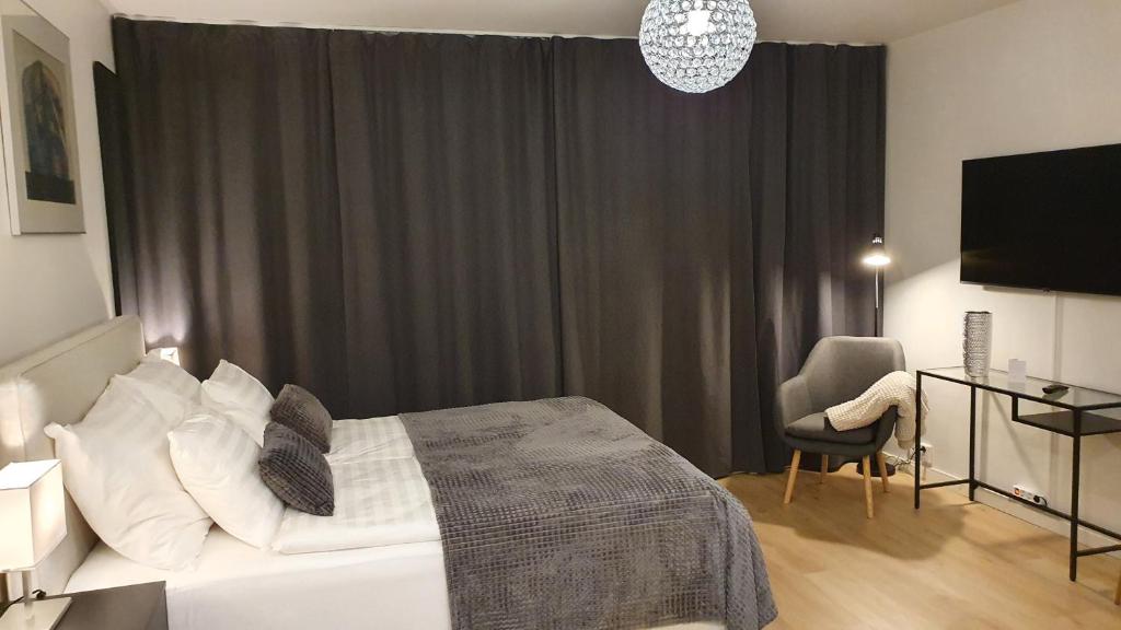 um quarto com uma cama, uma secretária e uma televisão em Myplace in Oulu Studio Koulukatu em Oulu