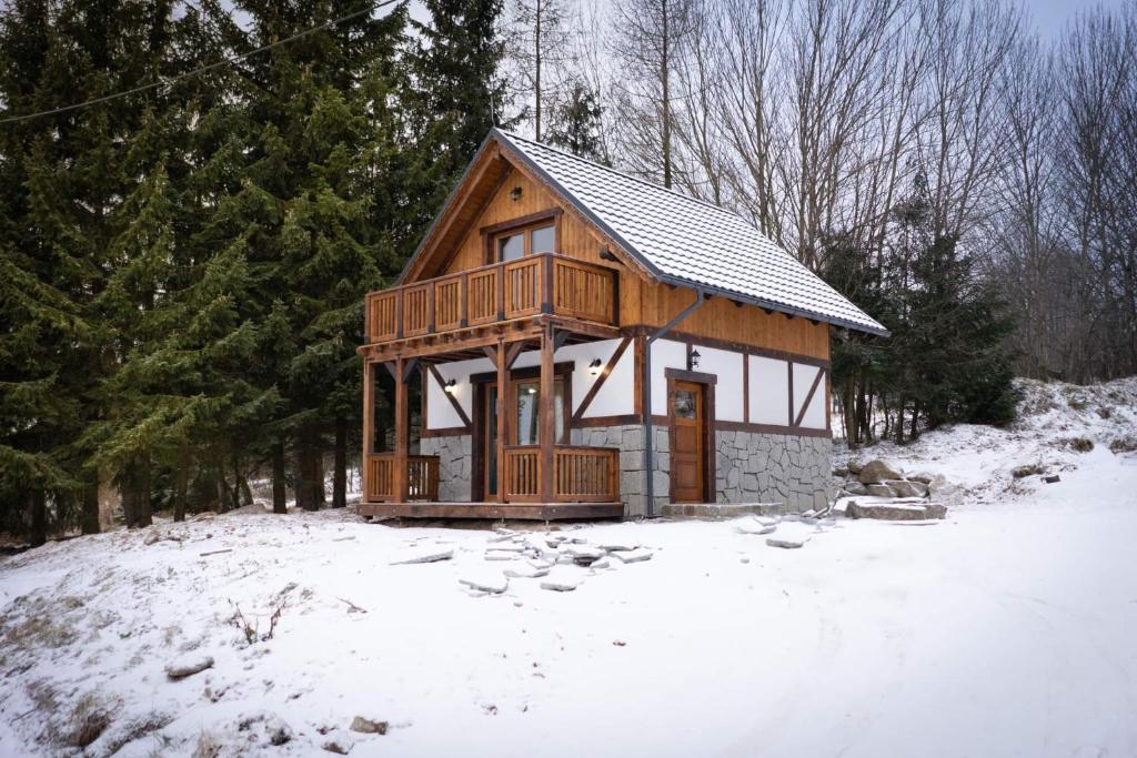 drewniany domek na śniegu z drzewami w obiekcie Domek Izery w Szklarskiej Porębie