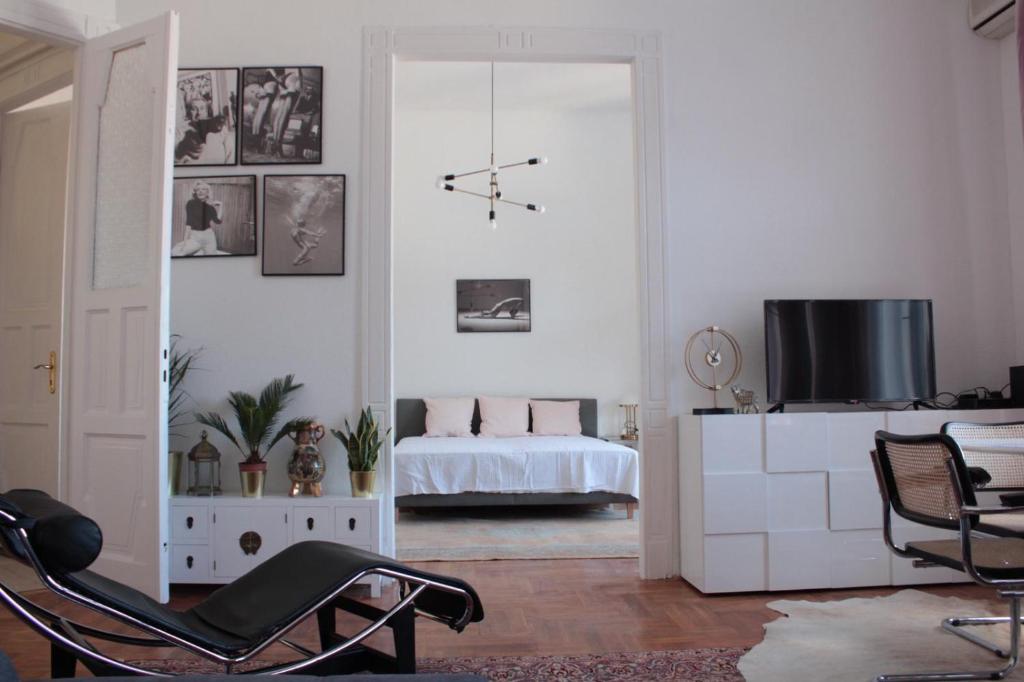 uma sala de estar com uma cadeira e uma televisão em Allomas Apartman em Budapeste