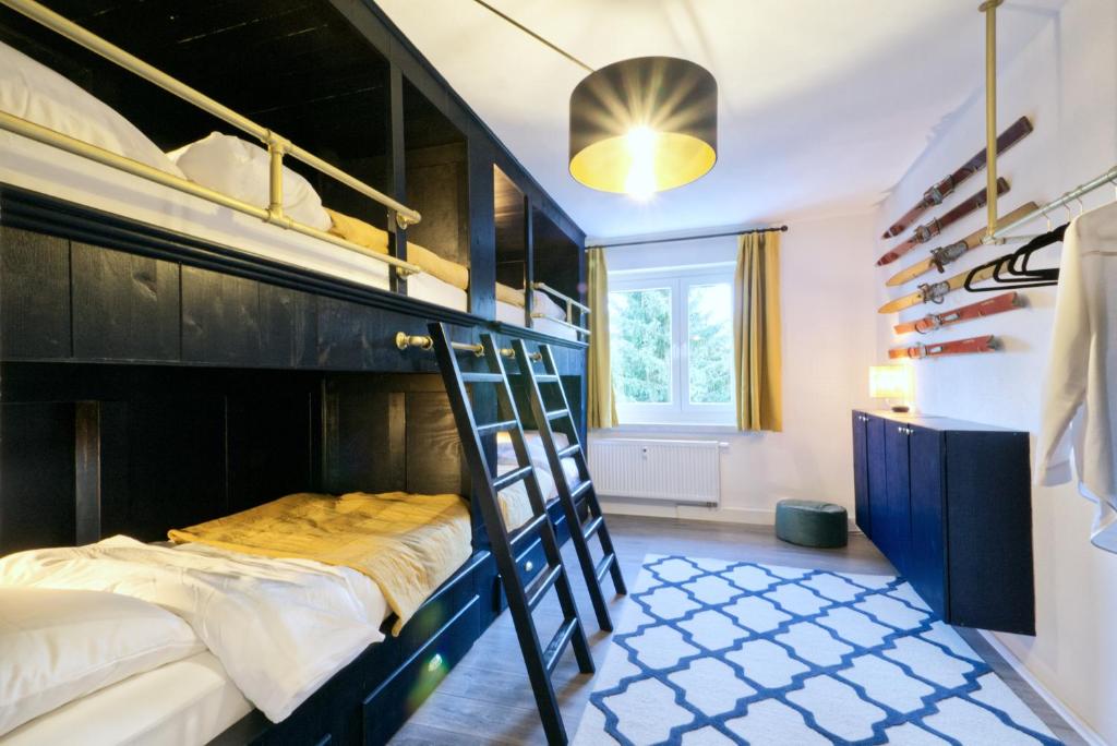 Erzgebirge Suite Bergruhe في كورورت أوبرفايسنتال: غرفة نوم بسريرين بطابقين وسلم