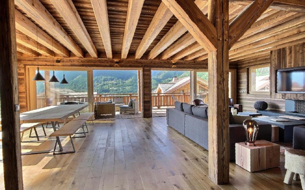 a living room with a couch and a table at Chalet Luxe piscine et spa 18 personnes serrechevalierholidays in Le Monêtier-les-Bains