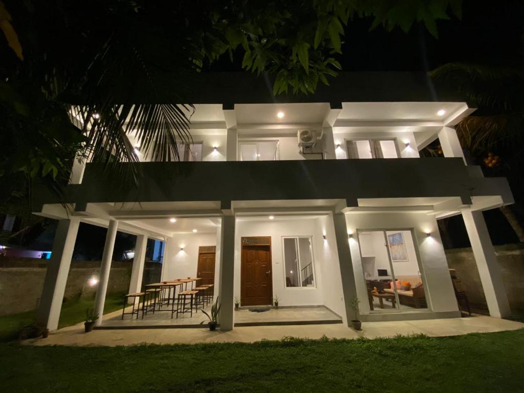 ein weißes Haus in der Nacht mit der Vorderseite in der Unterkunft Kalan Mirissa in Mirissa