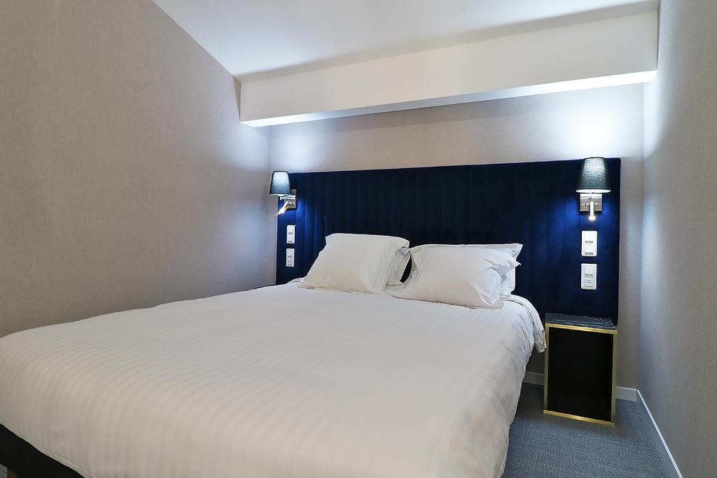 Postel nebo postele na pokoji v ubytování Hôtel Napoléon