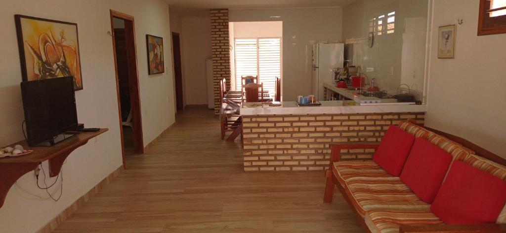 a living room with a couch and a kitchen at Casa Tropicana in Flecheiras