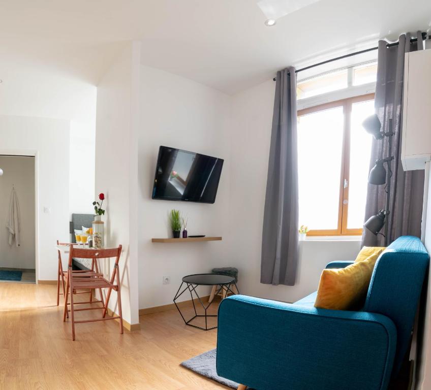 a living room with a blue couch and a table at Le Progrès in Villeurbanne