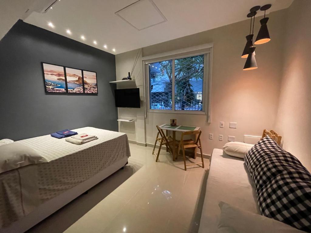 里約熱內盧的住宿－Namastê House Copacabana，一间卧室配有一张床、一张桌子和一个窗户。