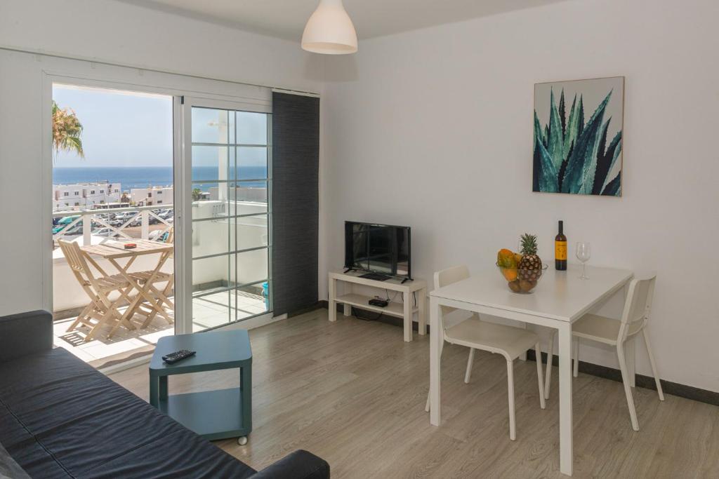 a living room with a table and a dining room at L & D in Puerto del Carmen