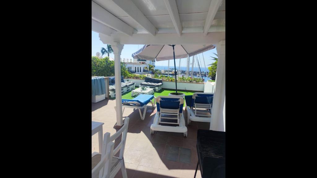 a patio with a table and chairs and an umbrella at First Line Luxury Apartment by El Sirocco in Puerto de Mogán
