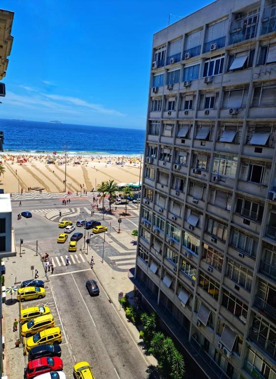 Hotel Studio_Copa_Clara, a building next to a beach with cars parked next to it at Studio_Copa_Clara in Rio de Janeiro