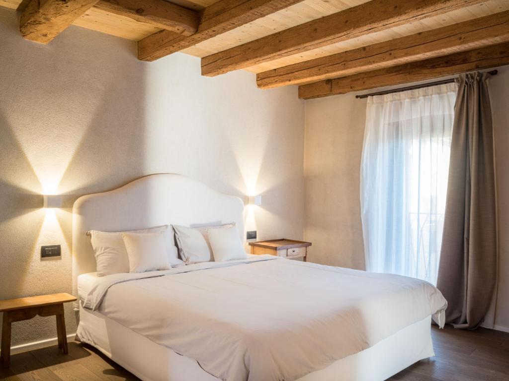 een slaapkamer met een wit bed en een raam bij Borgo San Verolo B&B in Castion Veronese
