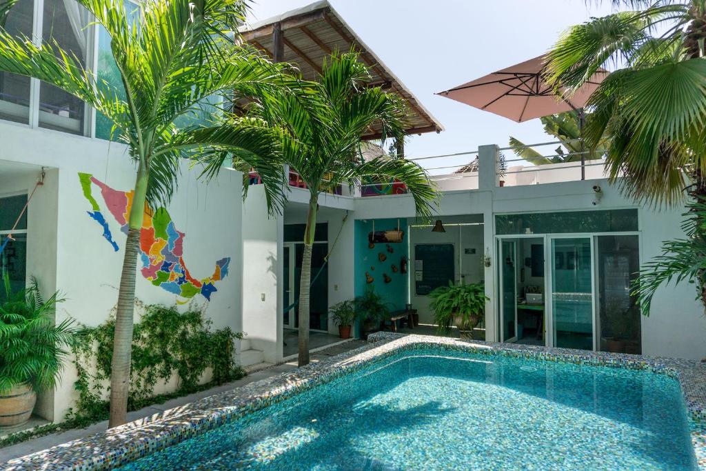 a villa with a swimming pool in front of a house at Casa Daikiri in Puerto Escondido