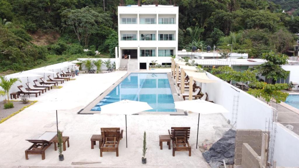an image of a resort with a swimming pool and tables and chairs at MALAKI in Los Ayala
