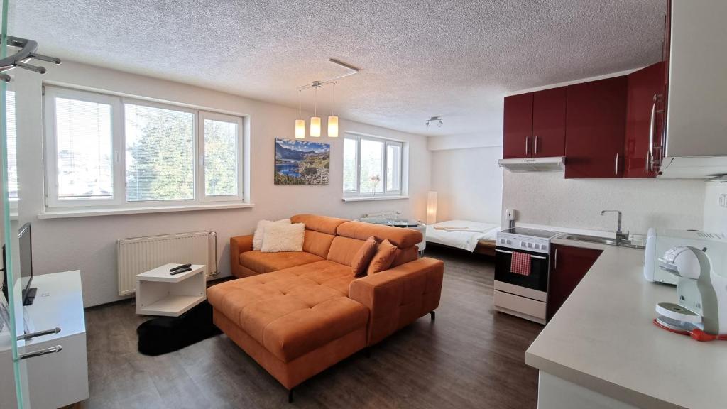 a living room with a couch and a kitchen at Apartmany Tilia in Nová Lesná