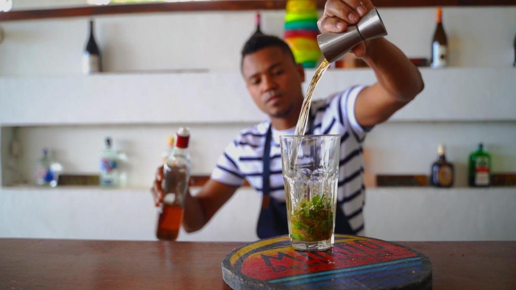 a man pouring a drink into a glass at Makao Beach Hotel in Palomino