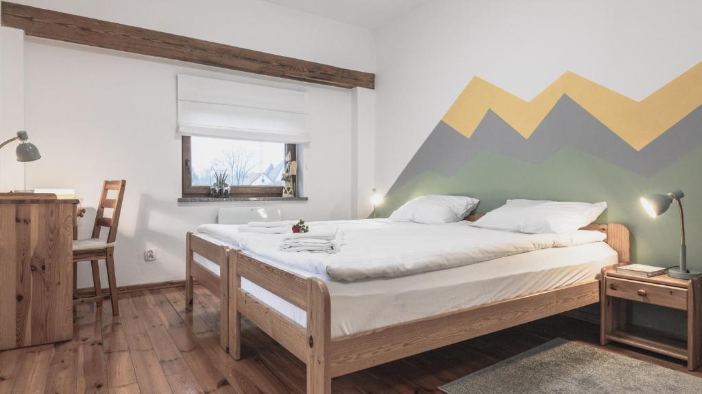 a bedroom with a bed with a mountain painted on the wall at Przystanek Czarne in Jelenia Góra