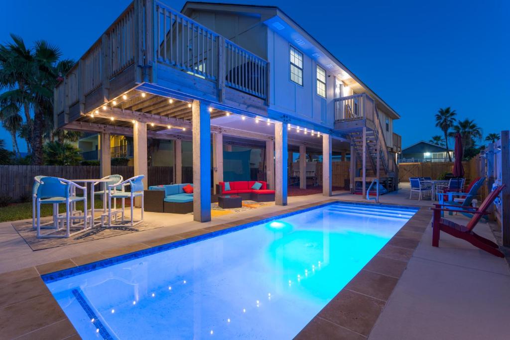 a house with a swimming pool in front of a house at House of Neptune Steps from the sea and private pool in South Padre Island