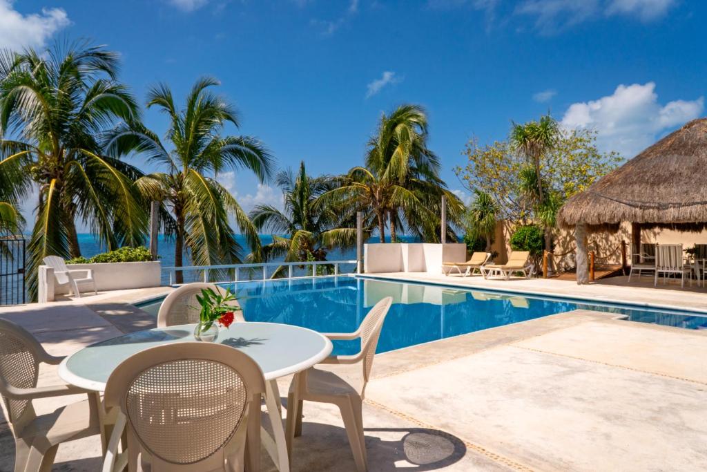 a patio with a table and chairs next to a swimming pool at Casa Bonita and villas in Isla Mujeres