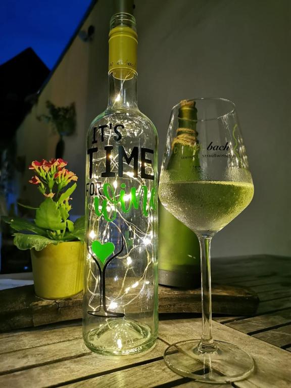 eine Flasche Wein und ein Glas auf dem Tisch in der Unterkunft Weingut Gästehaus Bach in Cochem