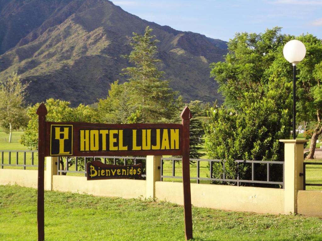 um sinal para uma biblioteca de hotel com uma montanha ao fundo em Hotel Lujan em Luján