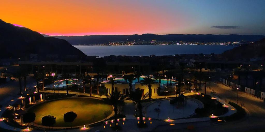 een uitzicht op een stad 's nachts met een zonsondergang bij Rental unit in RAHA village compound, special view in Aqaba